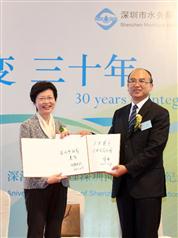 Mrs Lam (left) exchanges commemorative albums with the Mayor of Shenzhen, Mr Xu Qin. 