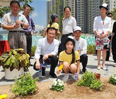 韋志成（前左）和韓志強（前右）與學生和地區人士一起參與種植活動。