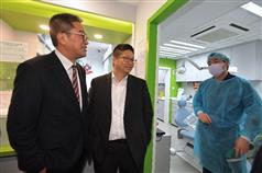 The Secretary for Development, Mr Michael Wong (left), visited the facilities of the Pok Oi Hospital Dental Service Support Base in Cheung Ching Community Centre during his visit to Kwai Tsing District today (February 18). Photo shows Mr Wong chatting with a dentist at the Support Base. Looking on is the Chairman of the Kwai Tsing District Council, Mr Law King-shing (centre). 