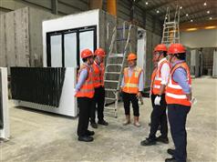 發展局局長黃偉綸（右二）今日（一月十三日）在新加坡裕廊港參觀一間為「組裝合成」組件加工的廠房，了解每件獨立組件的組裝工序和流程。圖左為一個已完成部分基本裝修、配件裝置和屋宇設施的獨立組件。
