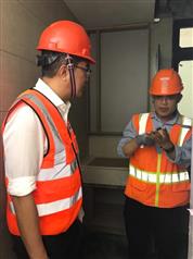 發展局局長黃偉綸（左）今日（一月十三日）在新加坡裕廊港參觀一間為「組裝合成」組件加工的廠房，了解每件獨立組件的組裝工序和流程。圖示工程人員向黃偉綸展示已完成部分基本裝修、配件裝置和屋宇設施的獨立組件。