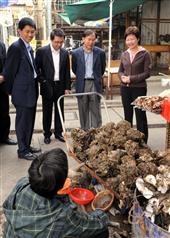 The Secretary for Development, Mrs Carrie Lam (right), chatting with an oyster stall operator in Lau Fau Shan. 
