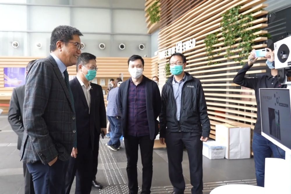 发展局局长黄伟纶（左一）听取创科公司代表介绍其研发的“体温探测移动机械人”。旁为机电署署长薛永恒（左二）。