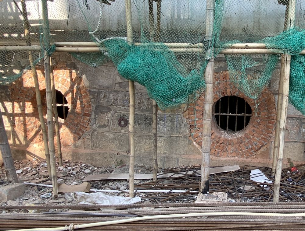 宿舍的主楼是一幢两层高的建筑物，其下层楼层筑有特厚的花岗岩石墙，墙上有圆形、像牛眼的窗。