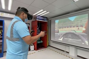 前线员工郑祖卫示范利用虚拟实境（Virtual Reality, VR）学习操作机械的情况。