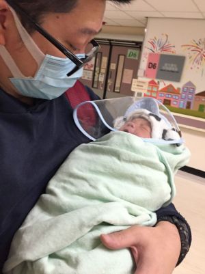 邓承恩去年年底第二次当爸爸，最紧张是怎样把幼子从医院接回家。图示他为幼子穿好个人防护装备离开医院的情形。