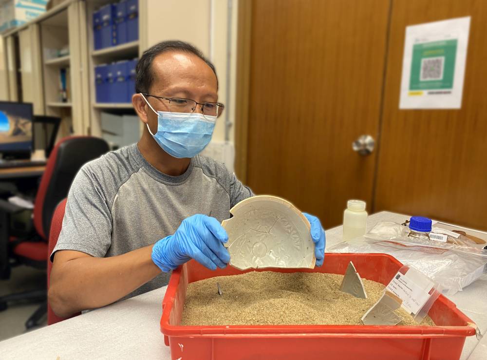 古迹办同事为器物进行拼对，并以特别的黏合剂把属于同一器物的碎片拼贴。