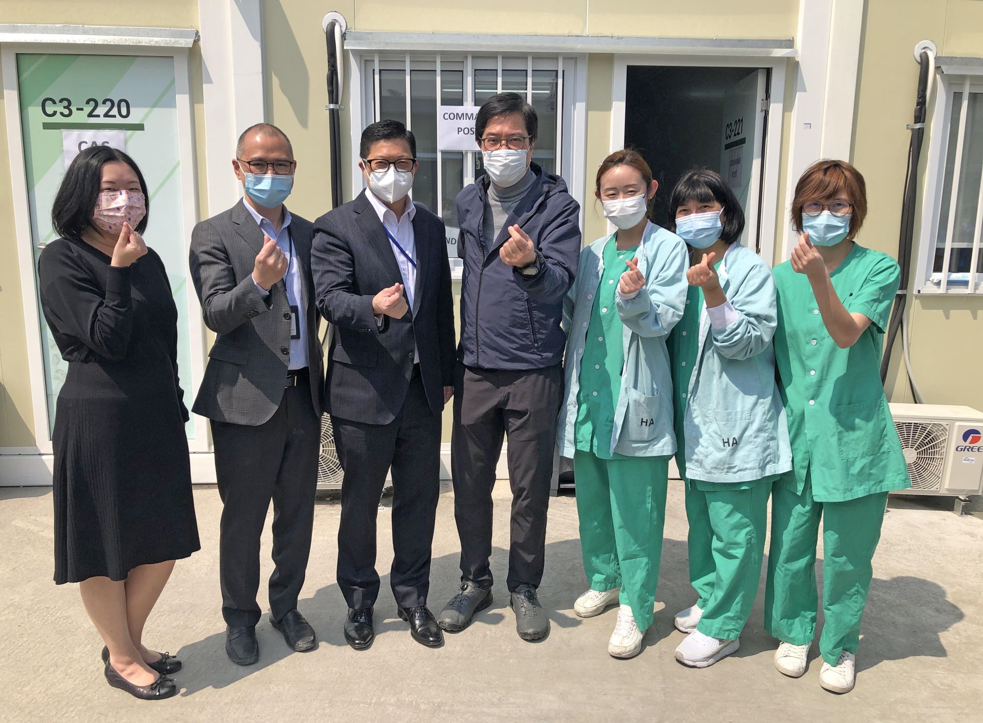 发展局局长黄伟纶（中）和保安局局长邓炳强（左三）日前（3月2日）视察青衣的小区隔离设施，并为前线医护人员打气。