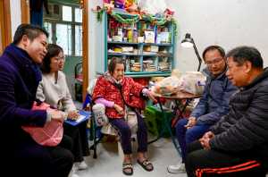 居于西营盘旧楼的业主邓生（右一）认为，楼宇过于老旧会失去价值，因此支持降低强拍门槛，以加快旧区重建。