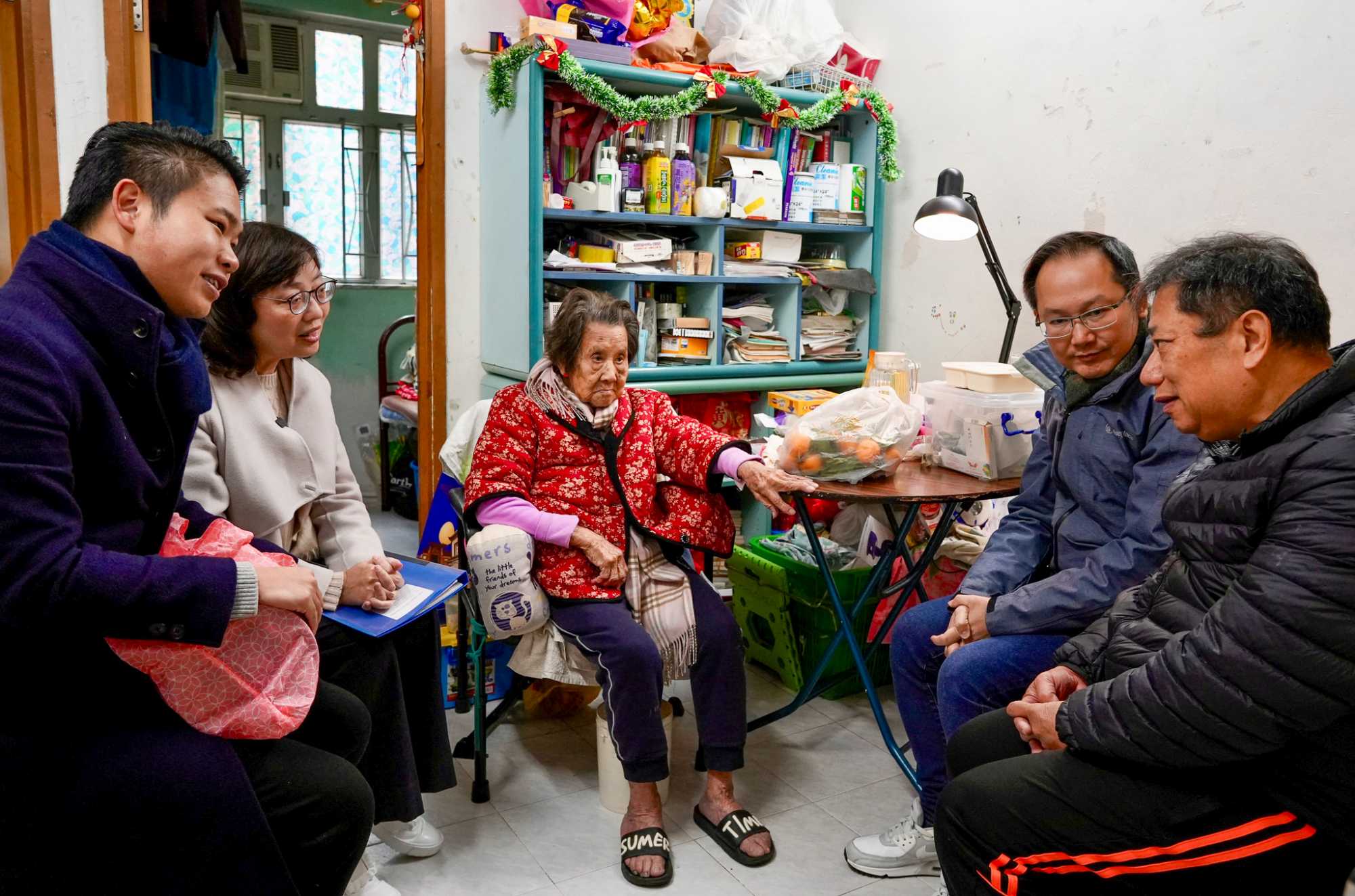 居于西营盘旧楼的业主邓生（右一）认为，楼宇过于老旧会失去价值，因此支持降低强拍门槛，以加快旧区重建。