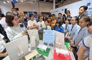 发展局局长甯汉豪（左一）与参展学校学生交流，并了解她们的创作。