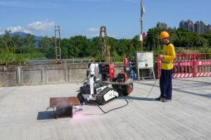 采用烧焊机械人后，曾先生表示不用再躺着进行「仰焊」，改善了其工作环境，并提高焊道的品质，生产力亦提升约两倍。图示曾先生使用烧焊机械人。