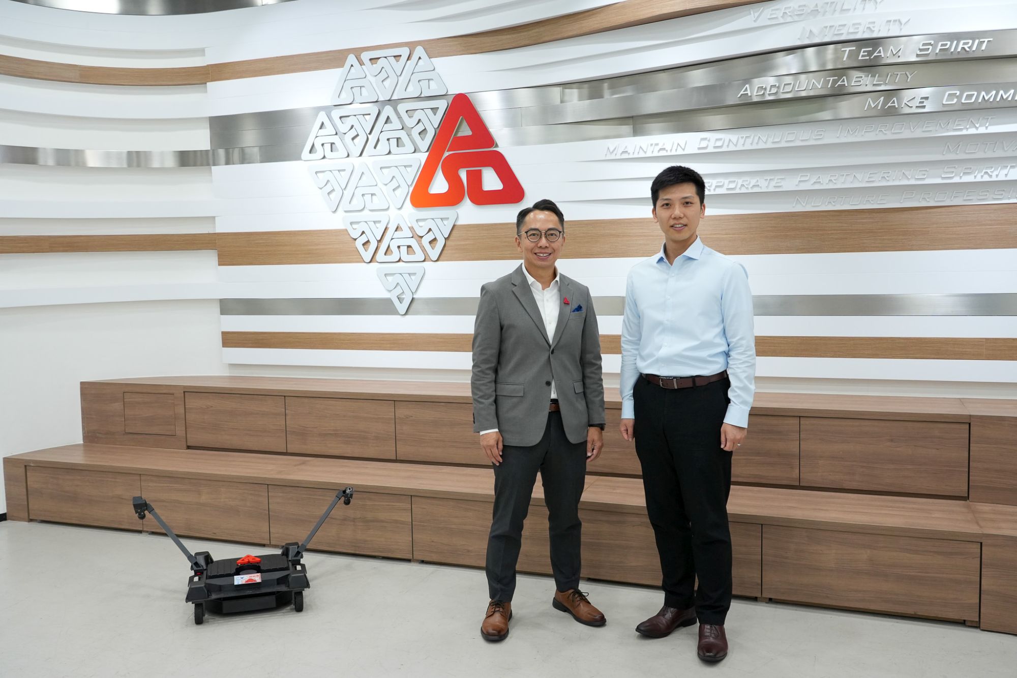 发展局助理秘书长（计划管理）罗梓馨（右）与建筑署总物业事务经理刘卓杰（左）介绍可近距离观察外墙的爬壁机器人。