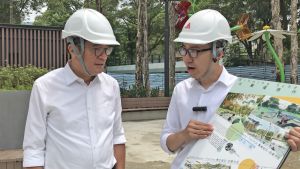 建築署園境師叢培淳（右）向黃偉綸局長（左）講解屯門公園共融遊樂場的場地設計概念。