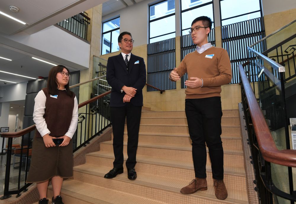 兩位青年文化保育大使王耿城（右）和王穎潼（左）向發展局局長黃偉綸（中）介紹法院的歷史及建築特色。