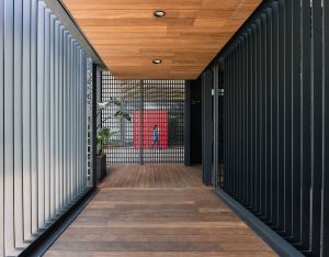 多用途室的門廊利用垂直和方格子的金屬線條作屏風，用以遮擋陽光之外，亦有助空氣流通。