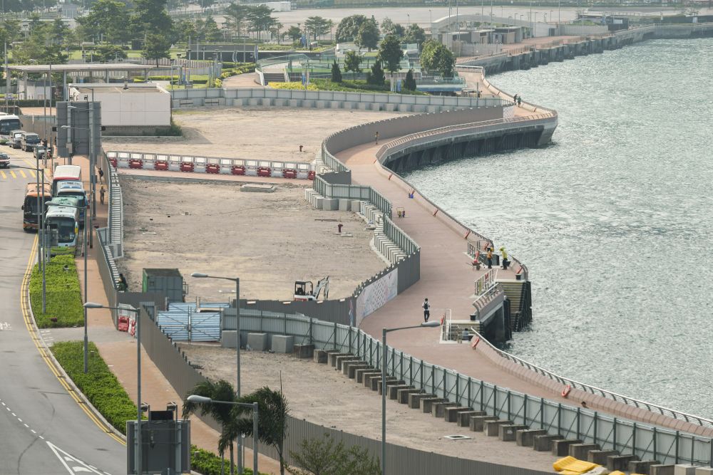 圖為添馬至會展已開通的海濱長廊及旁邊正在興建「童樂園」的工地。