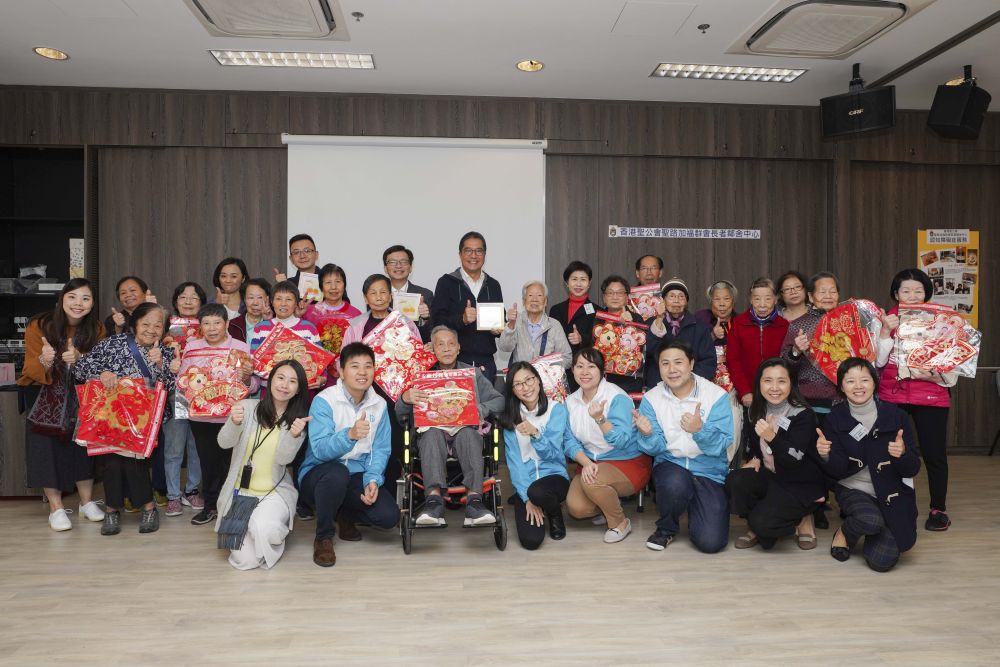 發展局局長黃偉綸（後排中）、副局長廖振新（後排左二）和政治助理馮英倫（後排左一）在香港聖公會福利協會總幹事李正儀博士（後排右二）、渠務署義工隊和聖公會長者義工的帶領下，1月22日探訪位於堅尼地城的香港聖公會聖路加福群會長者鄰舍中心，向老友記拜年。