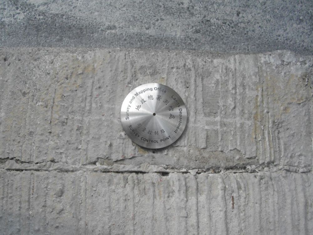 圖示行人道上的平面控制點，為測量提供平面位置參考。該控制點上刻有地政總署測繪處的字樣。