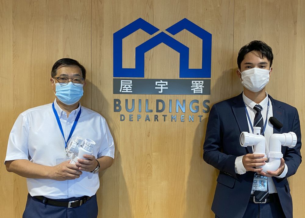 屋宇署屋宇測量師吳宇殷（右）在講座上講解排水系統的組成部分，以及檢查和維修渠管時所需的知識，並即時解答參與者在網上提出的問題。左為屋宇署高級專業主任鄧國權。