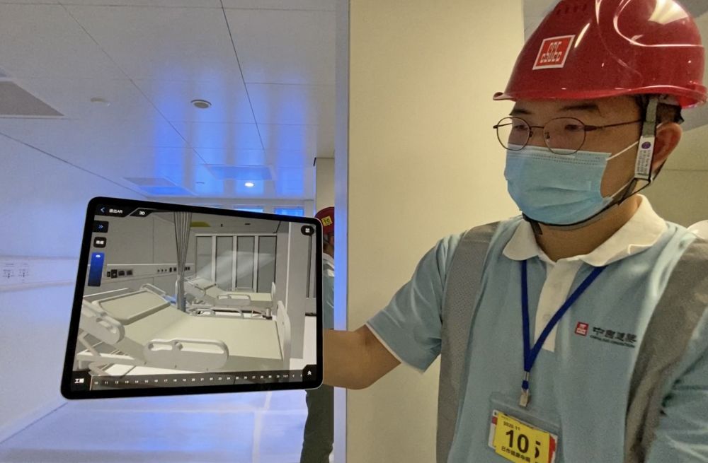 工程團隊設計和建造臨時醫院期間，引入多項智能系統。圖為工作人員示範如何利用擴增實境（Augmented Reality，簡稱AR）技術，模擬病房的實際情況，協助現場安裝。