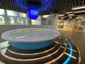 圖示展城館的新展品—「規劃視窗」，透過一個像眼球的圓形屏幕，配合香港地貌模型上的互動投影，加上聲光效果，帶訪客進入一段探索香港規劃與基建發展的旅程。