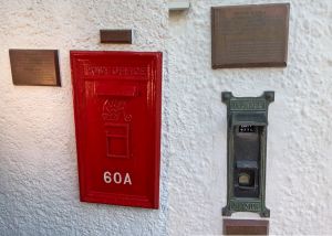 赤柱郵政局保存了不少舊有建築特色，例如鑄鐵郵箱（圖左）、原有的人手操作郵票售賣機（圖右）、原裝窗花等。