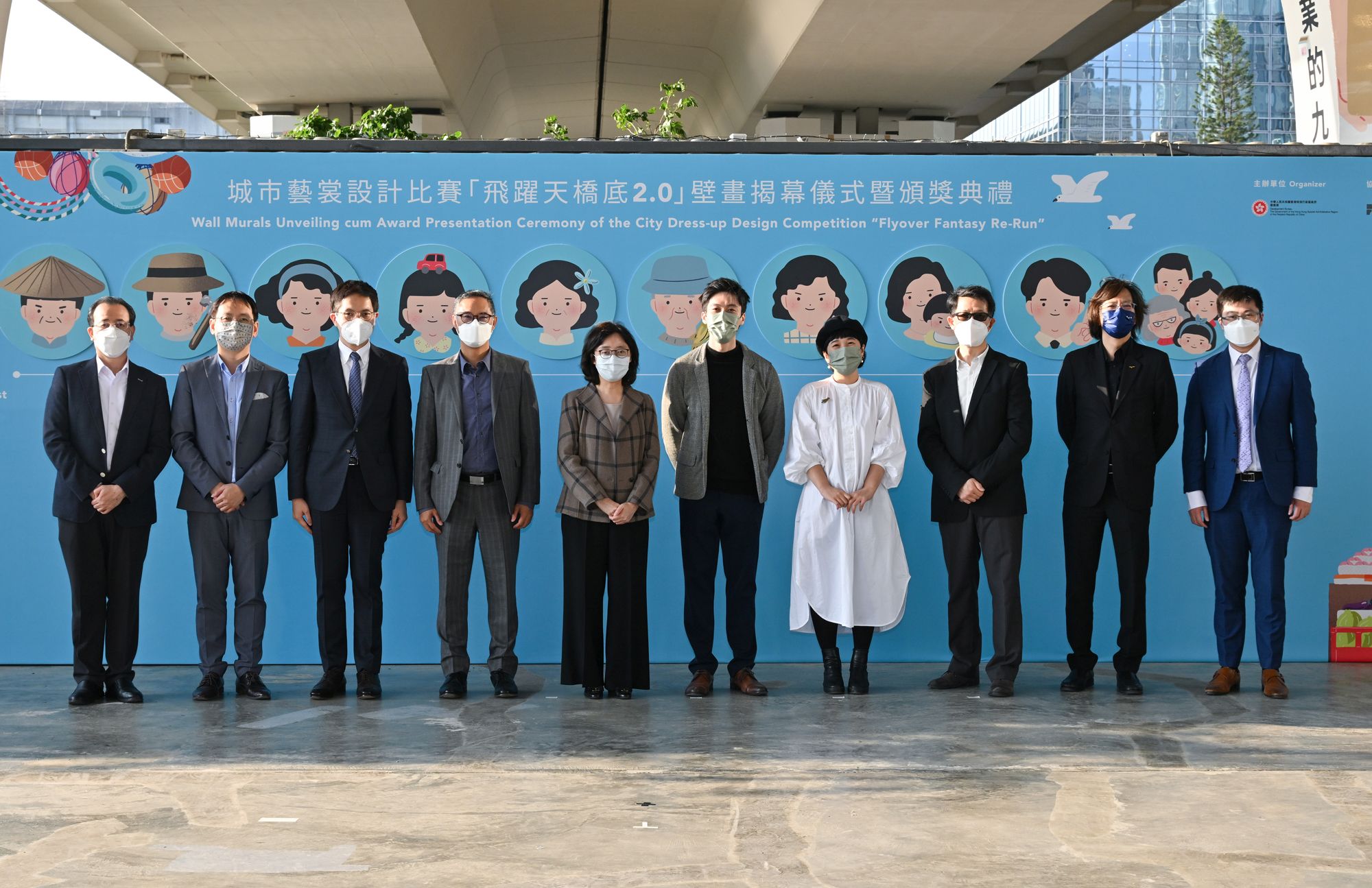 「城市藝裳設計比賽―飛躍天橋底2.0」早前舉行開幕及頒獎禮。圖示發展局局長甯漢豪（左五）、發展局常任秘書長（工務）劉俊傑（左四）、署理起動九龍東專員景國祥（右三）與主禮嘉賓及得獎的建築師梁安裕（右五）和設計師龍曉琳（右四）合照。