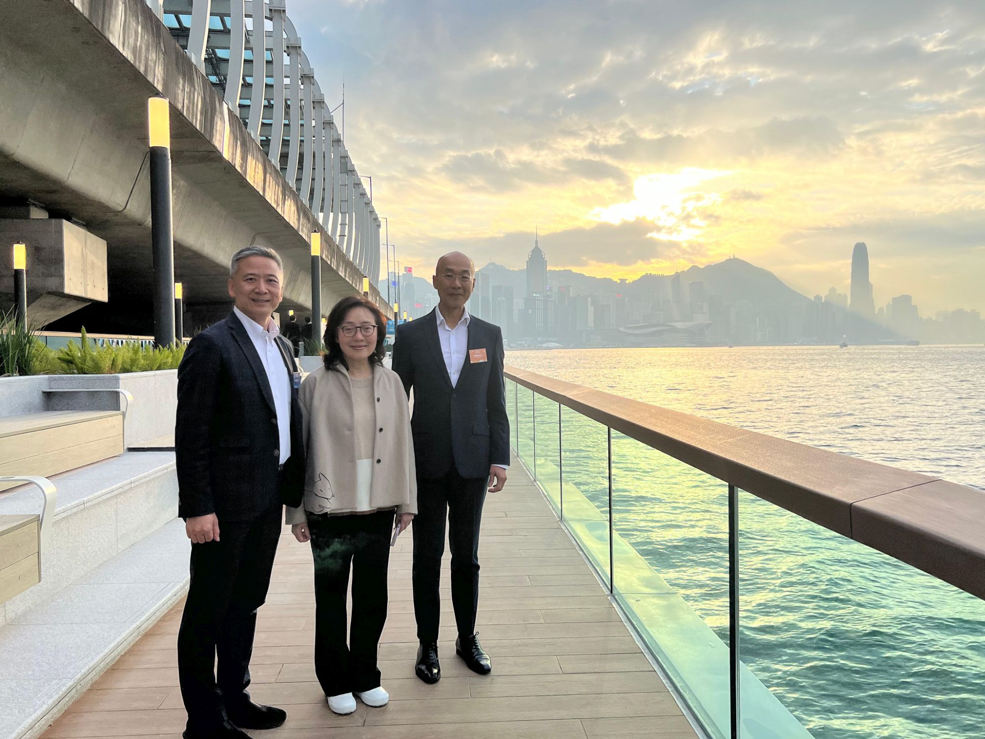 （左起）立法會議員姚柏良（旅遊界）、發展局局長甯漢豪與土木工程拓展署署長方學誠在東岸板道與徐徐落下的夕陽合照。