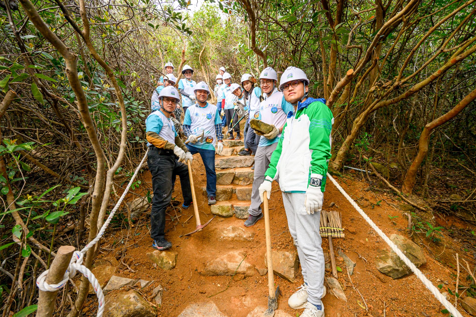 土木工程拓展署署長方學誠（上圖左一）與市民及部門義工隊親身參與建造行山徑，打造每一道石級，以手作步道方式興建行山徑。下圖為完成後的行山徑。