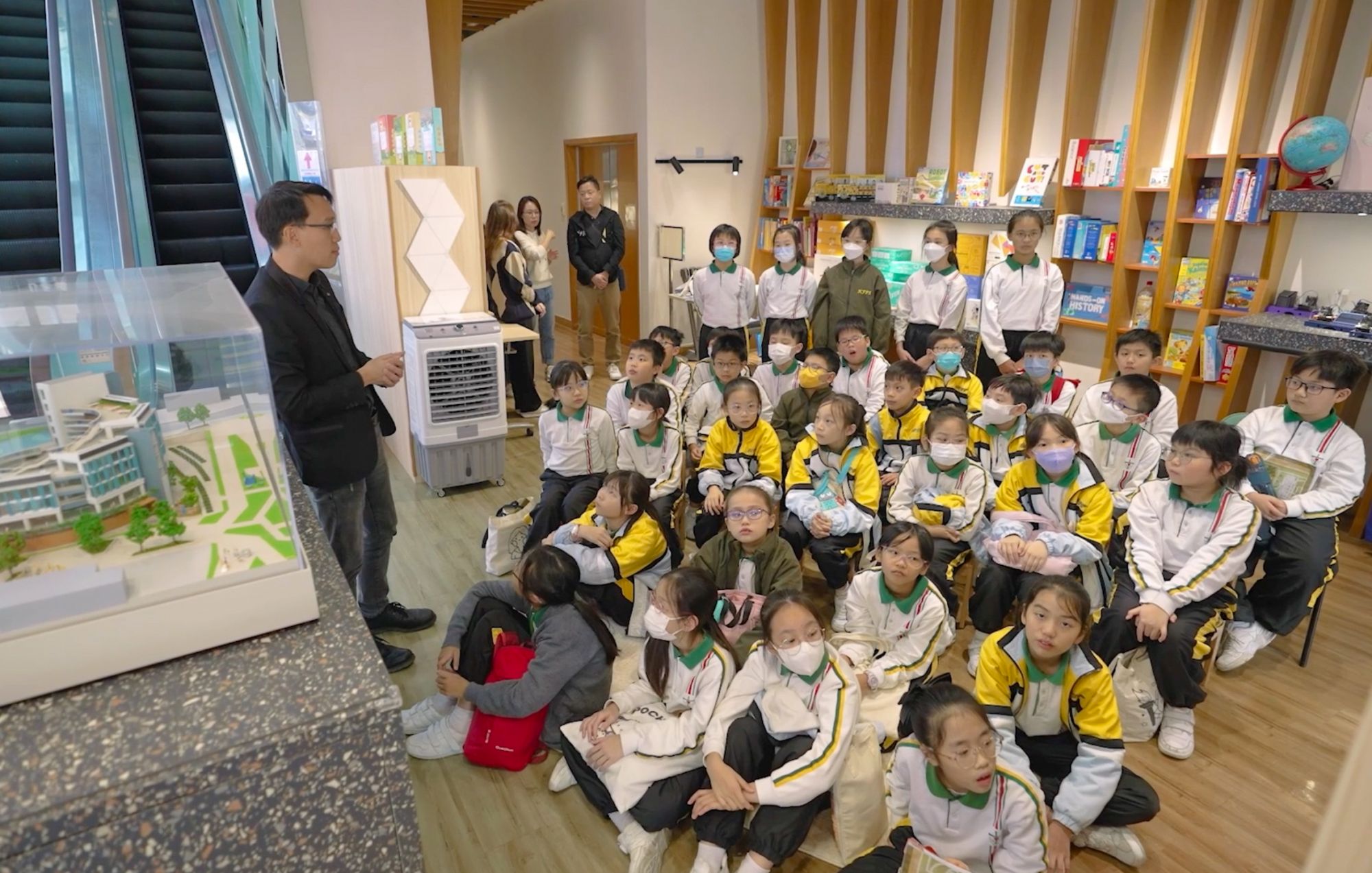 項目亦會邀請工程師、建築師及測量師等專業人士走進課堂，與學生分享實際工程案例。圖為建築師向學生介紹基建設施。