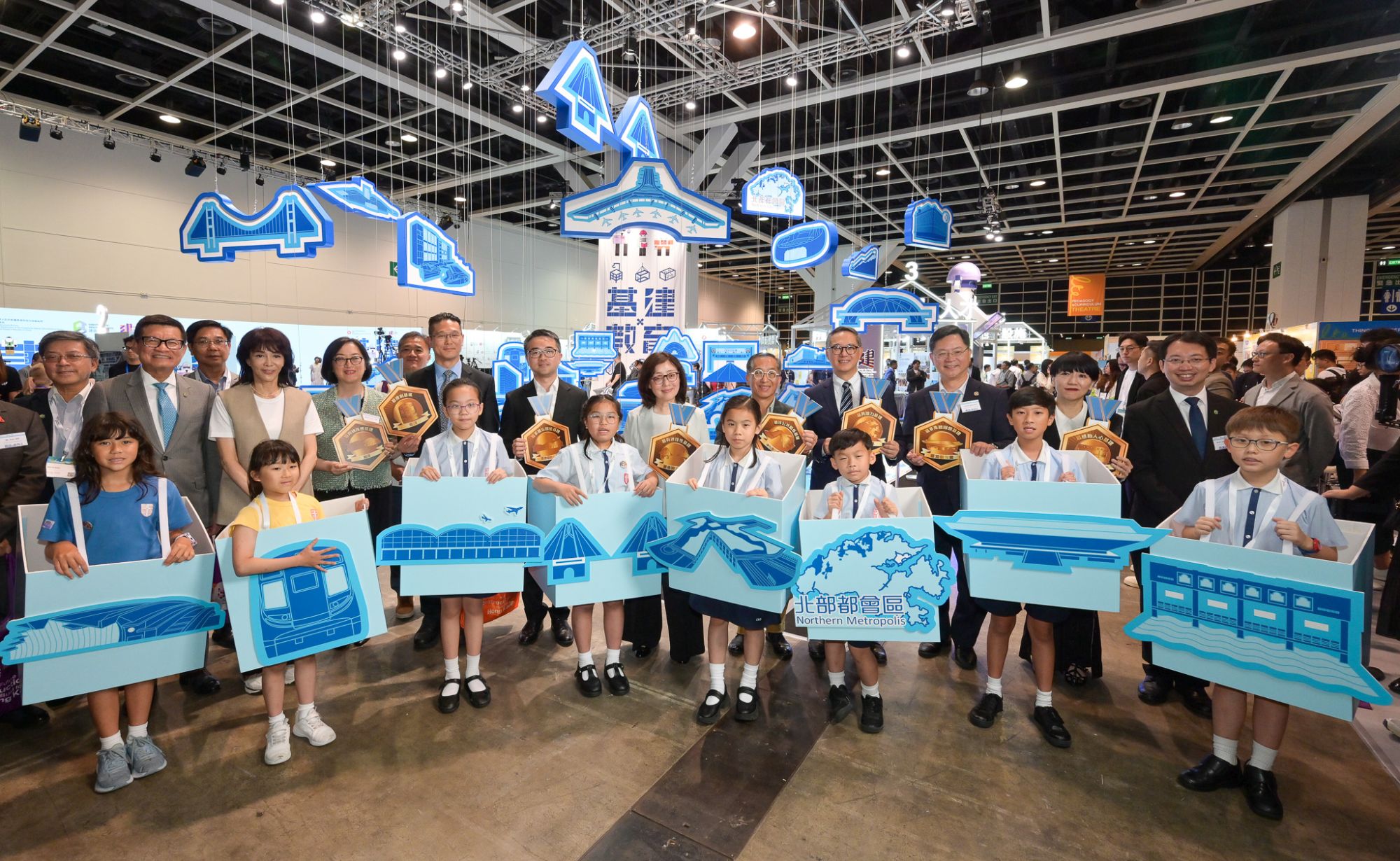 圖示發展局局長甯漢豪（後排右六）、發展局常任秘書長（工務）劉俊傑（後排右四）、教育局副局長施俊輝（後排右七）、建造業議會主席何安誠教授（後排右五）和建造業議會執行總監鄭定寕（後排左二）在香港首個立體基建地圖前與其他嘉賓及學生合照。