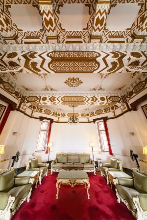 天花的金漆灰塑橫樑，既加強樓板的承載力，同時帶來華麗的天花視覺效果。窗戶配有彩色玻璃、花崗石窗框和中式圖案的金屬窗芯。圖示大宅內的中式飯廳。