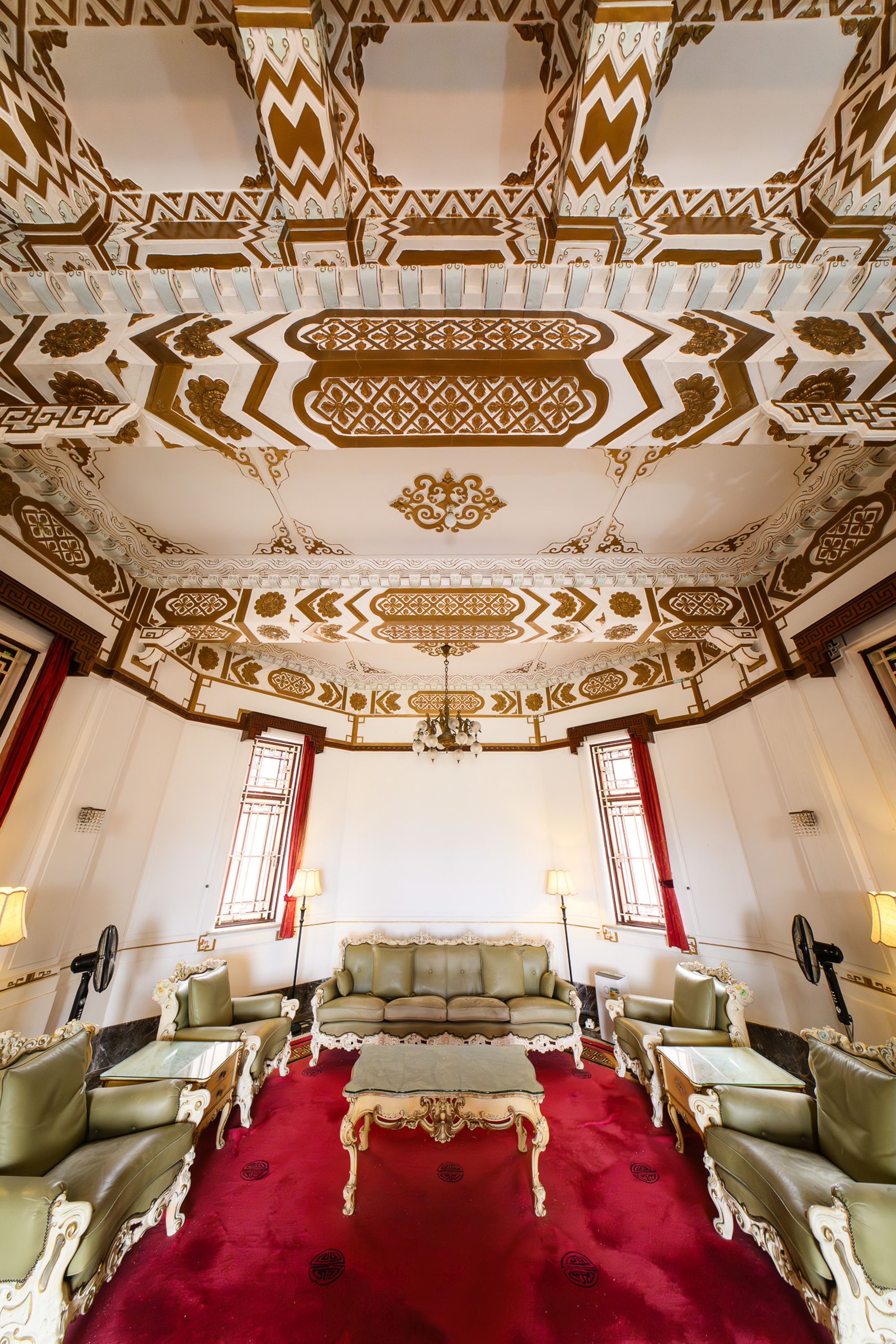 天花的金漆灰塑橫樑，既加強樓板的承載力，同時帶來華麗的天花視覺效果。窗戶配有彩色玻璃、花崗石窗框和中式圖案的金屬窗芯。圖示大宅內的中式飯廳。