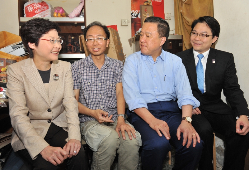 林鄭月娥（左一）、張震遠（右二）與油尖旺區議會主席鍾港武（右一）在記者會後探訪大角咀杉樹街市區重建局「需求主導」重建項目的其中一名戶主。 (Image)