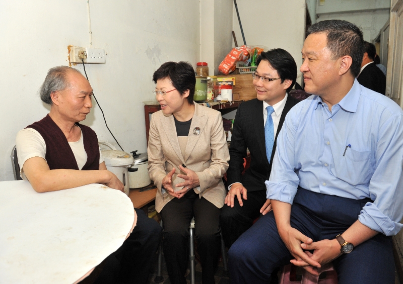 林鄭月娥（左二）、張震遠（右一）與鍾港武（右二）在記者會後探訪大角咀杉樹街市區重建局「需求主導」重建項目的其中一名戶主。 (Image)