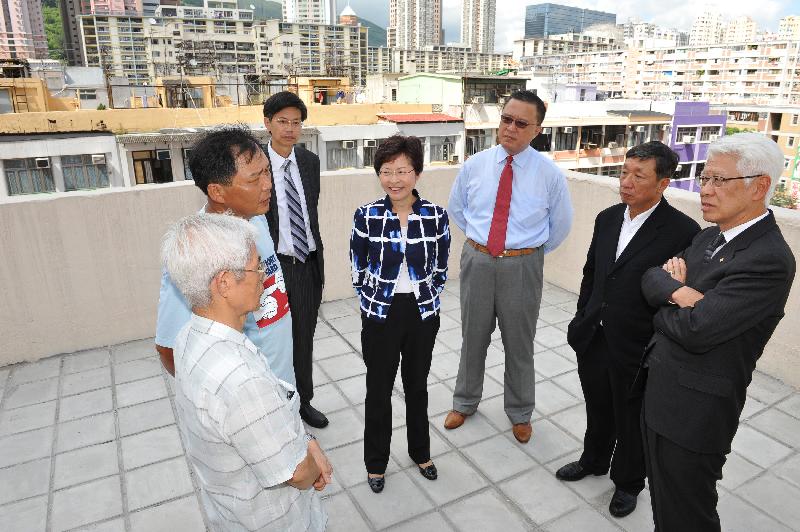 發展局局長林鄭月娥聯同香港房屋協會主席楊家聲（右一）、市區重建局主席張震遠（右三）及荃灣區議會主席陳耀星（右二），到荃灣享成街美華樓參觀，該大廈透過樓宇更新大行動進行了維修及保養工程。圖示林鄭月娥與大廈業主立案法團主席及一位自住業主傾談。 (Image)