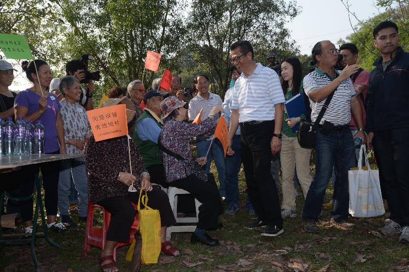 陳茂波（右五）到訪虎地村，聽取村民的訴求。.