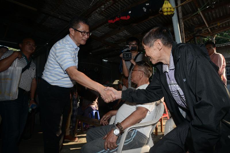 陳茂波（左二）到訪天平山村，與村民會面。.