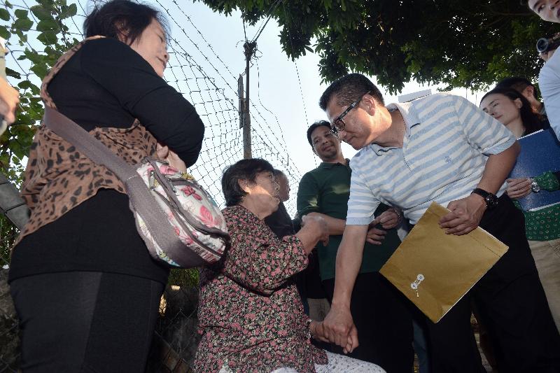 陳茂波（右）到訪石湖新村，聽取村民的訴求。.