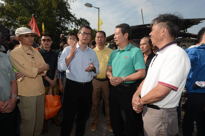 陳茂波（左二）向村民闡釋計劃的內容。.