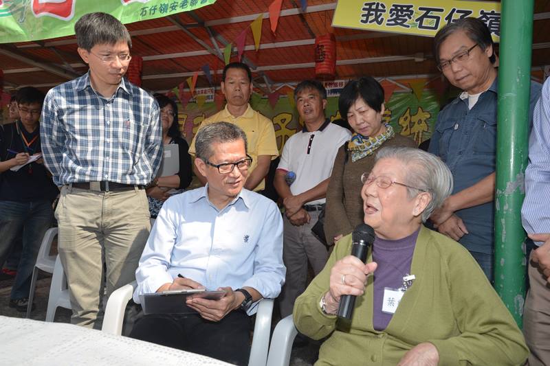 陳茂波（左二）聆聽「石仔嶺花園」安老院院友對搬遷的關注。.