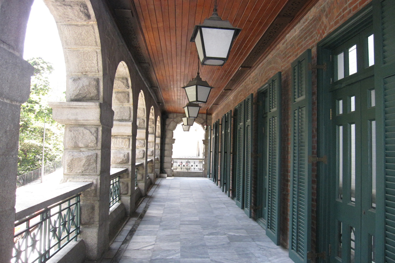 舊精神病院外廊的吊燈、木板天花和百葉木門。