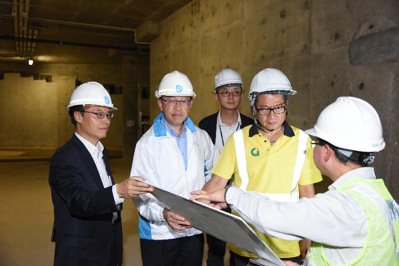 The Secretary for Development, Mr Paul Chan (second right), the Political Assistant to Secretary for Development, Mr Allen Fung (centre), the Director of Drainage Services, Mr Edwin Tong (second left), and the Assistant Director (Operations and Maintenance), Mr Fedrick Kan, are briefed on the works progress of the Happy Valley Underground Stormwater Storage Scheme by the Chief Engineer (Drainage Projects), Mr Kan Hon-shing.