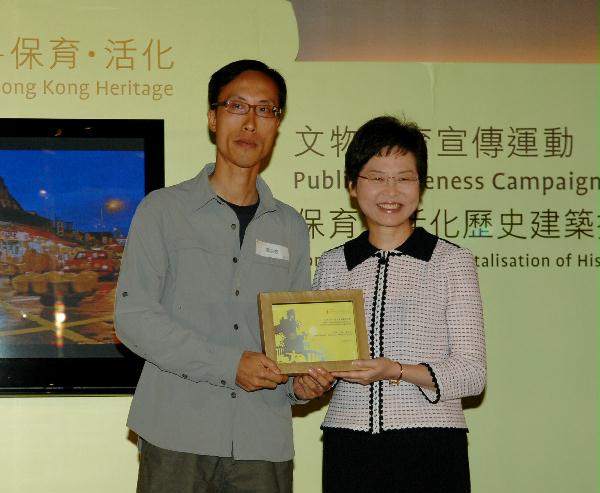 發展局局長林鄭月娥今日（四月十九日）在尖沙咀香港文物探知館舉行的「保育及活化歷史建築攝影比賽」頒獎禮上頒發獎項予公開組冠軍黃志強。