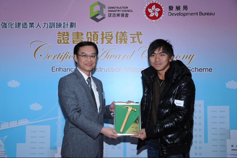 The Permanent Secretary for Development (Works), Mr Wai Chi-sing (left), presents a plaque to an outstanding graduate of the course for metal formwork erector and concrete, Mr Chan Ho-lap.