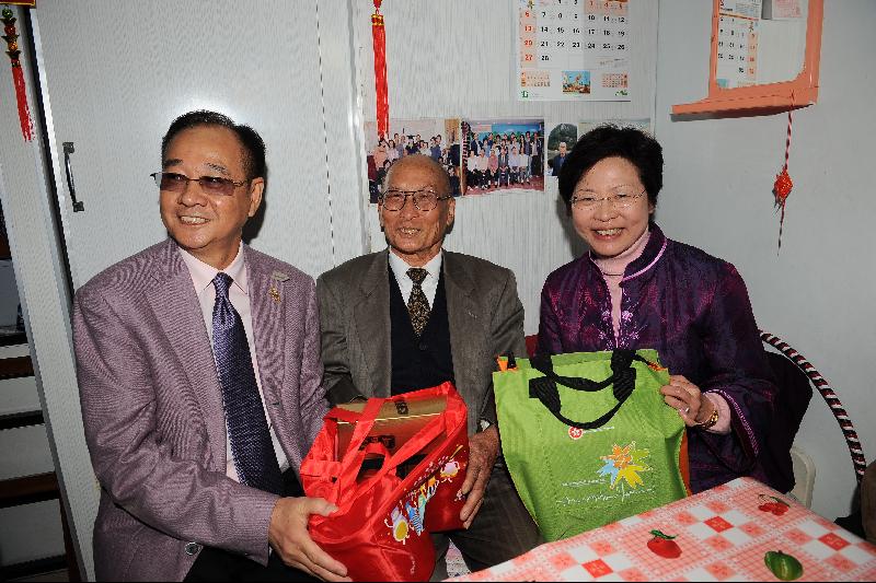 Mrs Lam presents a Lunar New Year gift to an elderly resident (centre) of St Peter's Village.