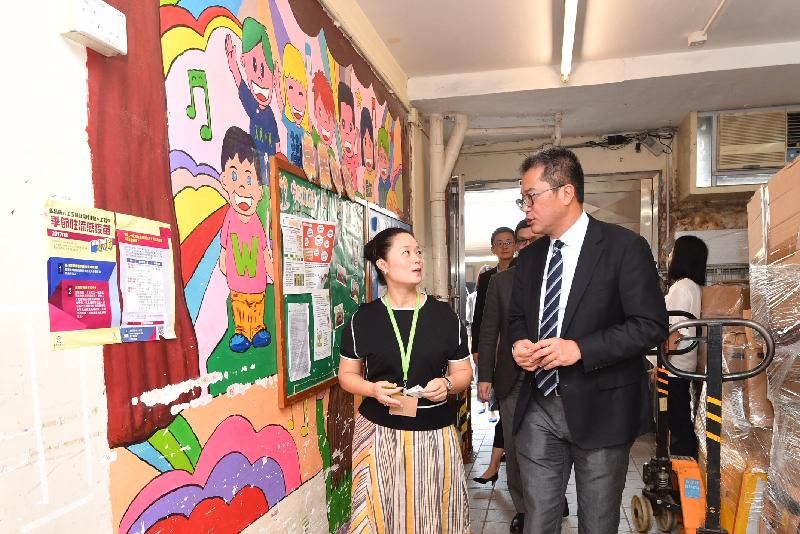 發展局局長黃偉綸今日（八月二十四日）在到訪沙田區期間，參觀香港唐氏綜合症協會卓業中心。圖示黃偉綸（右）聽取中心負責人介紹庇護工場的設施。