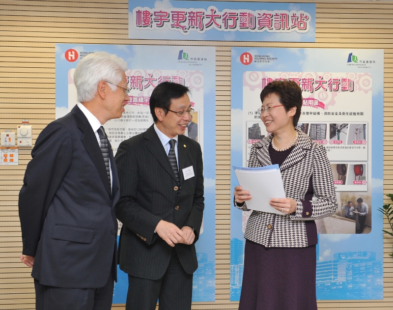 發展局局長林鄭月娥（右）參觀香港房屋協會物業管理諮詢中心（中區）內的「樓宇更新大行動」資訊站時，與房協主席楊家聲（左）交談。